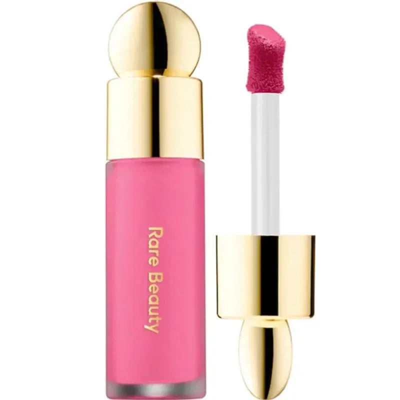 Labial líquido rosa con aplicador, empaque dorado y texto Rare Beauty en el frasco