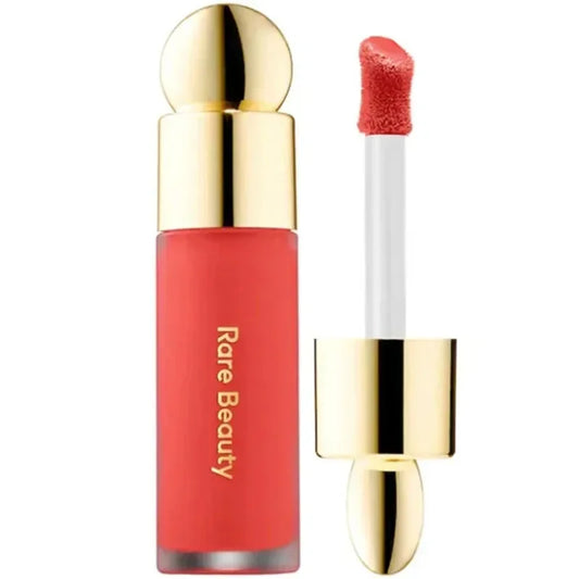 Labial líquido rojo Rare Beauty con aplicador y tapa dorada elegante.