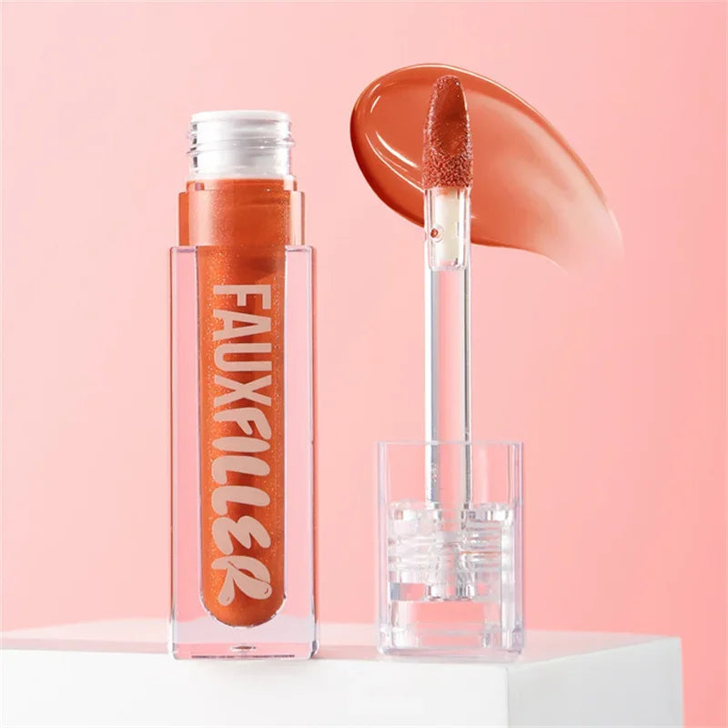 Brillo labial líquido color coral con aplicador, maquillaje sobre fondo rosa