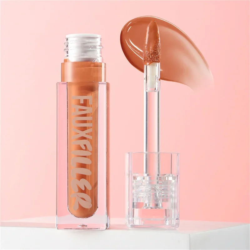 Brillo de labios nude en envase transparente con aplicador sobre fondo rosa, maquillaje labial.
