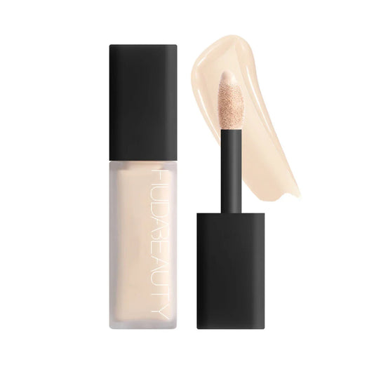 Corrector líquido tono claro con aplicador tipo esponja y envase negro, maquillaje facial