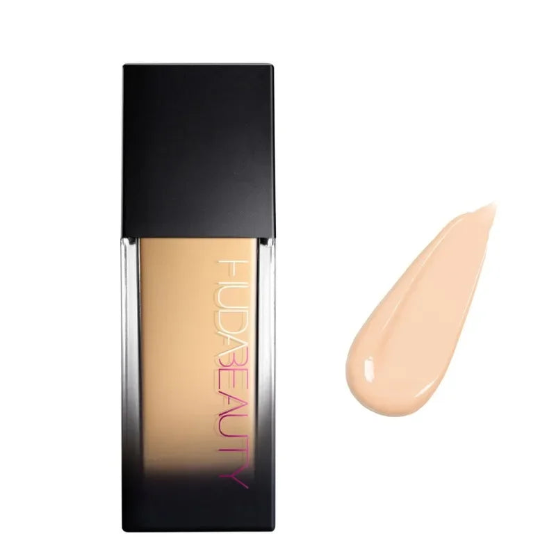 Base de maquillaje líquido tono claro en envase rectangular y muestra de color beige claro