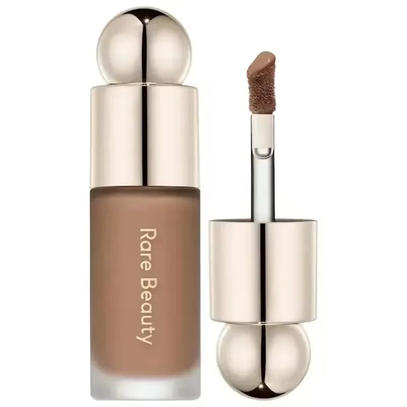 Corrector líquido tono marrón con aplicador, maquillaje Rare Beauty, fondo blanco