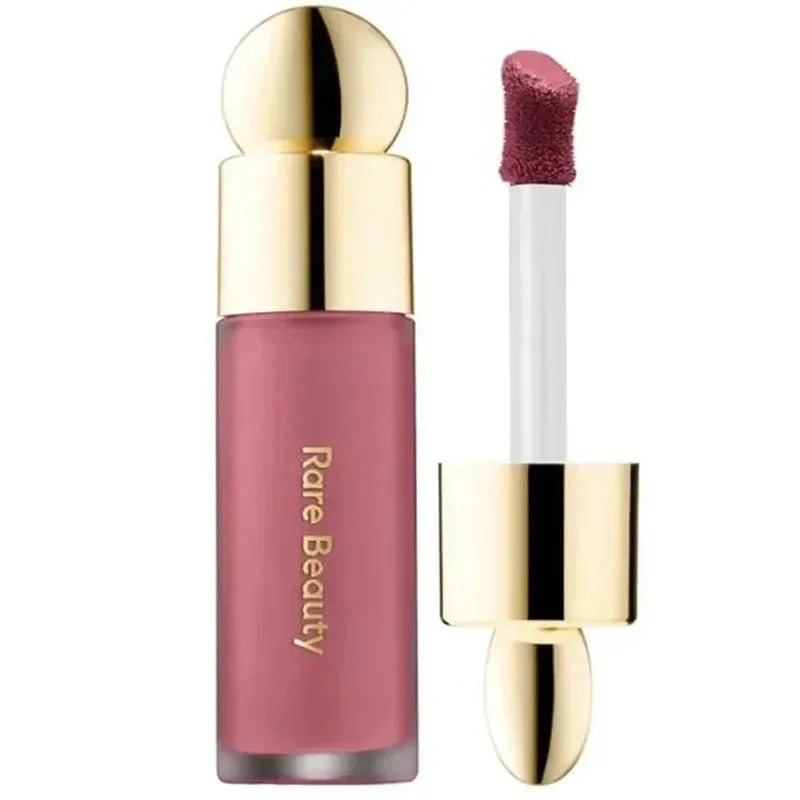 Rubor líquido Rare Beauty color rosa con aplicador y tapa dorada para maquillaje