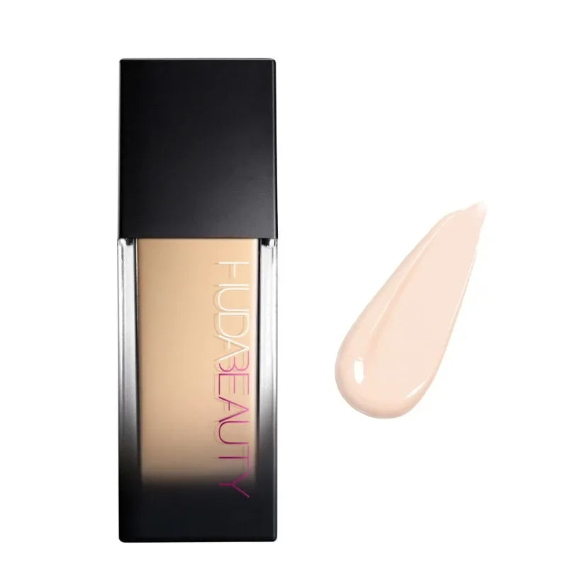 Base de maquillaje líquida tono claro en envase rectangular, muestra de color al lado