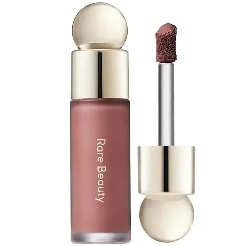 Labial líquido mate Rare Beauty color rosa nude con aplicador dorado.